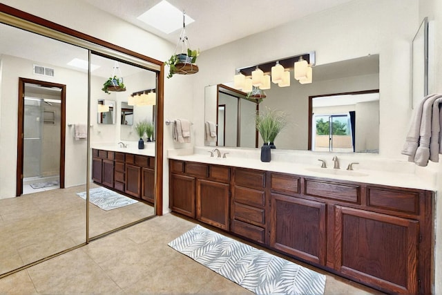 3039 Prenda De Oro Dr NW, Albuquerque, NM 87120 - bathroom with double vanity, a stall shower, a skylight, and tile patterned floors