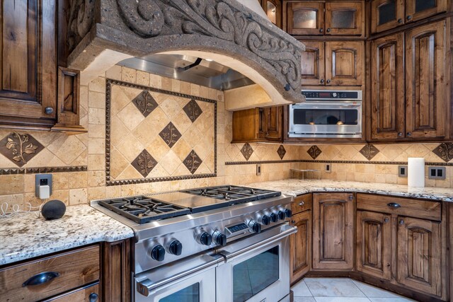 9301 Black Farm Ln NW, Albuquerque, NM 87114 - kitchen with double oven range, tasteful backsplash, and light stone countertops