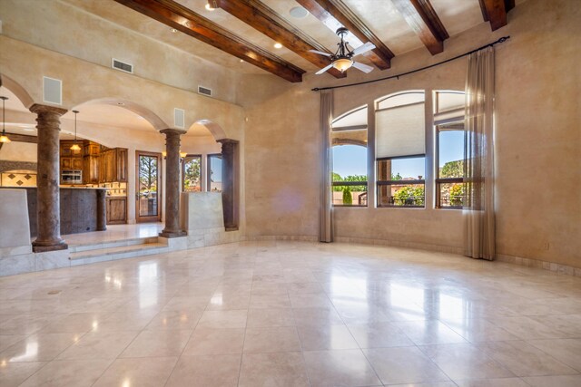 9301 Black Farm Ln NW, Albuquerque, NM 87114 - unfurnished living room with ornate columns, beam ceiling, arched walkways, a towering ceiling, and ceiling fan