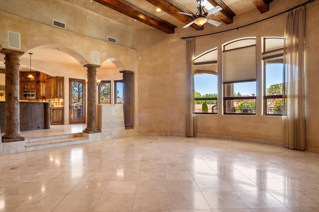9301 Black Farm Ln NW, Albuquerque, NM 87114 - unfurnished living room featuring ornate columns, beam ceiling, a towering ceiling, arched walkways, and ceiling fan