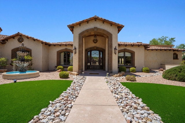 9301 Black Farm Ln NW, Albuquerque, NM 87114 - property entrance with stucco siding, a tile roof, and a lawn