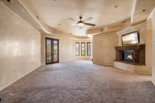 9301 Black Farm Ln NW, Albuquerque, NM 87114 - unfurnished living room featuring carpet, a glass covered fireplace, ceiling fan, french doors, and a raised ceiling