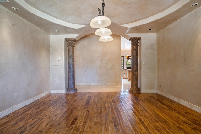 9301 Black Farm Ln NW, Albuquerque, NM 87114 - spare room featuring decorative columns, wood-type flooring, and arched walkways