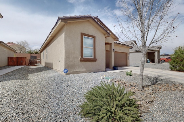 1854 Valle Vista Rd NW, Los Lunas, NM 87031 - view of front of home featuring stucco siding, a garage, driveway, and a tiled roof
