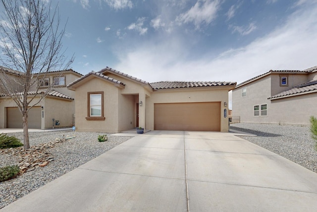 1854 Valle Vista Rd NW, Los Lunas, NM 87031 - view of front facade featuring stucco siding, a tiled roof, a garage, and driveway
