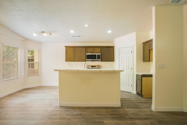 7113 Avignon Ct NW, Albuquerque, NM 87114 - kitchen featuring stainless steel microwave, wood finished floors, a kitchen island with sink, baseboards, and recessed lighting