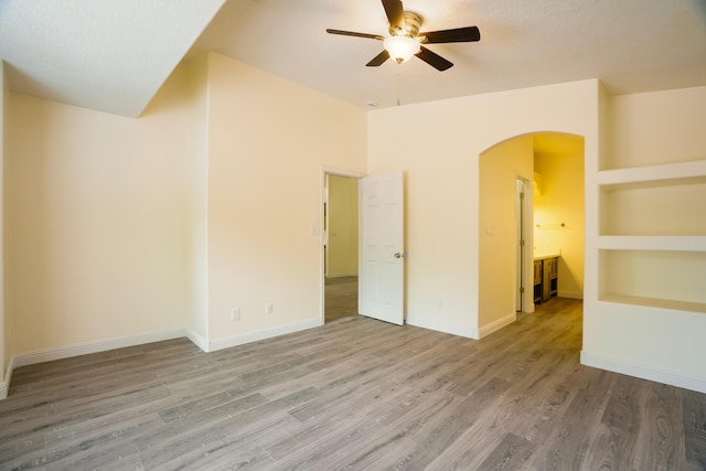 7113 Avignon Ct NW, Albuquerque, NM 87114 - unfurnished room with arched walkways, a ceiling fan, wood finished floors, baseboards, and built in features