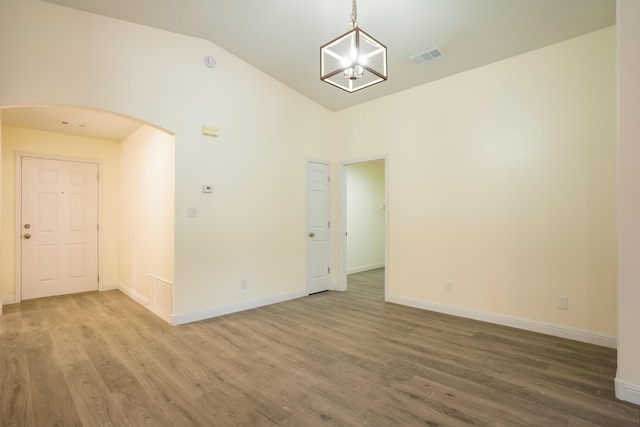 7113 Avignon Ct NW, Albuquerque, NM 87114 - empty room featuring arched walkways, wood finished floors, lofted ceiling, and baseboards