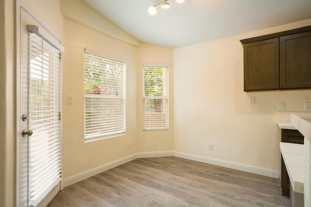 7113 Avignon Ct NW, Albuquerque, NM 87114 - unfurnished dining area with lofted ceiling, light wood finished floors, and baseboards