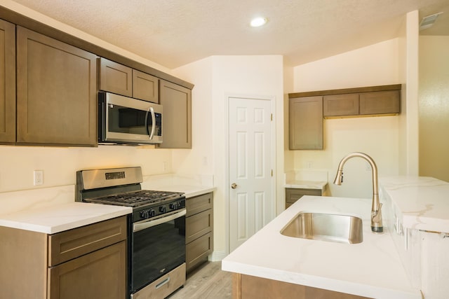 7113 Avignon Ct NW, Albuquerque, NM 87114 - kitchen with stainless steel appliances, a sink, light wood finished floors, light stone counters, and recessed lighting