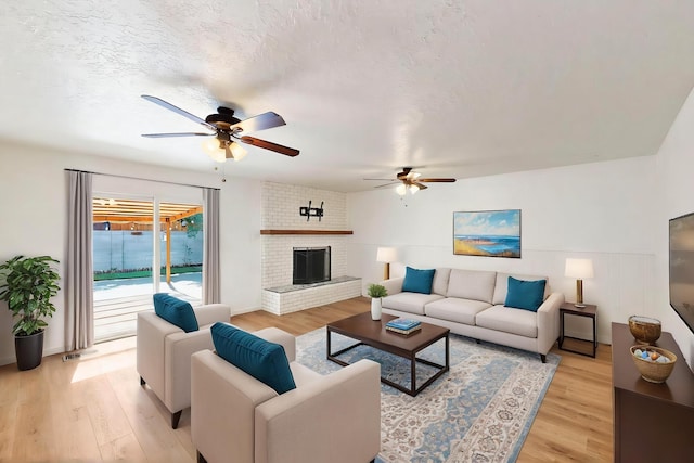 2912 Alcazar St NE, Albuquerque, NM 87110 - living area with a ceiling fan, light wood-type flooring, and a fireplace