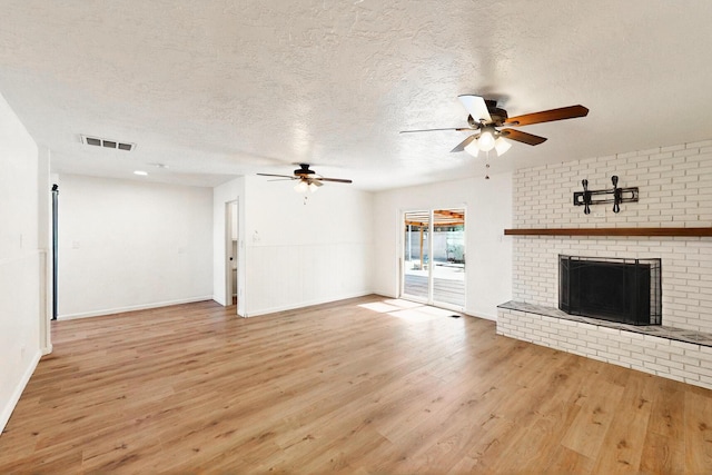 2912 Alcazar St NE, Albuquerque, NM 87110 - unfurnished living room with ceiling fan, light wood-style floors, a textured ceiling, a fireplace, and baseboards