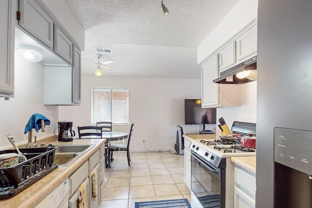 402 Calle Don Santiago NE, Los Lunas, NM 87031 - kitchen featuring gas range, under cabinet range hood, light countertops, ceiling fan, and freestanding refrigerator