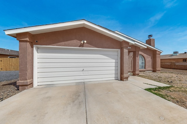402 Calle Don Santiago NE, Los Lunas, NM 87031 - view of front of house featuring stucco siding, a garage, concrete driveway, and a chimney
