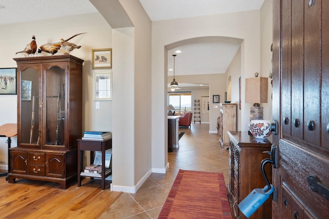 6413 Kings Cyn NE, Rio Rancho, NM 87144 - entrance foyer with arched walkways, light tile patterned floors, baseboards, and a textured ceiling