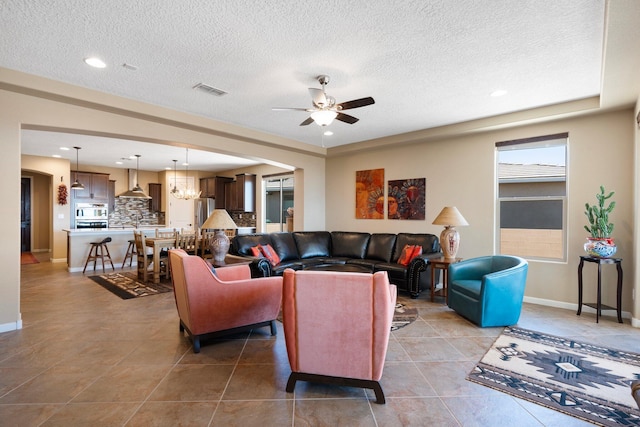6413 Kings Cyn NE, Rio Rancho, NM 87144 - living area featuring a ceiling fan, light tile patterned flooring, a chandelier, a textured ceiling, and baseboards