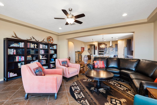 6413 Kings Cyn NE, Rio Rancho, NM 87144 - living area featuring ceiling fan, dark tile patterned flooring, recessed lighting, arched walkways, and a textured ceiling