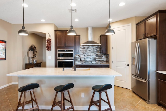 6413 Kings Cyn NE, Rio Rancho, NM 87144 - kitchen featuring appliances with stainless steel finishes, wall chimney exhaust hood, backsplash, light tile patterned floors, and recessed lighting
