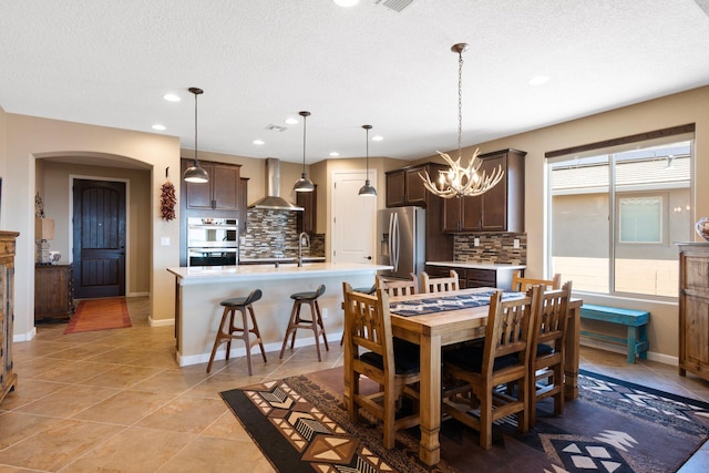 6413 Kings Cyn NE, Rio Rancho, NM 87144 - dining room with arched walkways, a textured ceiling, a chandelier, recessed lighting, and baseboards