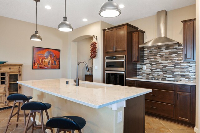 6413 Kings Cyn NE, Rio Rancho, NM 87144 - kitchen featuring wall chimney range hood, a sink, black electric cooktop, stainless steel double oven, and backsplash
