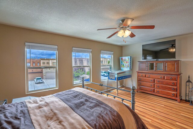 1921 Cortina Loop SE, Rio Rancho, NM 87124 - bedroom with light wood-type flooring, a textured ceiling, and ceiling fan