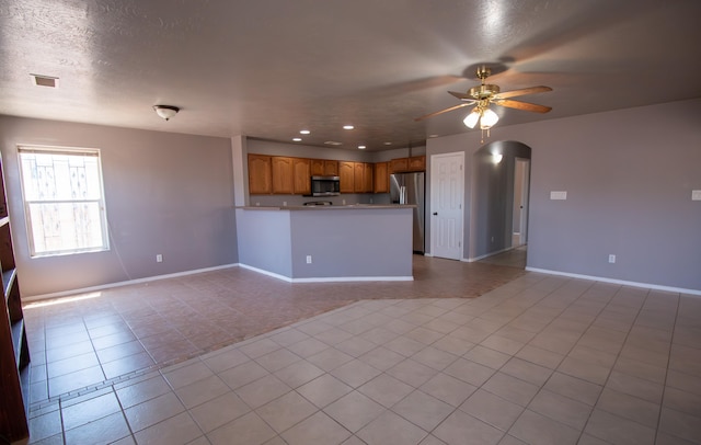 5112 W Lea Dr SW, Albuquerque, NM 87105 - unfurnished living room featuring ceiling fan, arched walkways, baseboards, tile patterned flooring, and recessed lighting