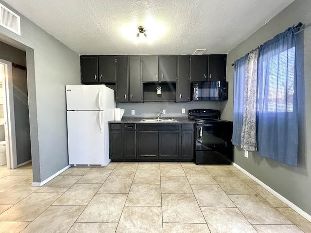 820 Apache Ave NW, Albuquerque, NM 87102 - kitchen with black appliances, a sink, a textured ceiling, dark cabinets, and baseboards