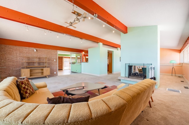 4818 Royene Ave NE, Albuquerque, NM 87110 - living room with carpet flooring, rail lighting, beam ceiling, baseboards, and brick wall