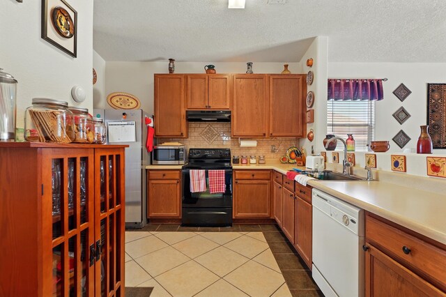 3401 Sun Mesa St SW, Los Lunas, NM 87031 - kitchen featuring appliances with stainless steel finishes, under cabinet range hood, a sink, a textured ceiling, and decorative backsplash