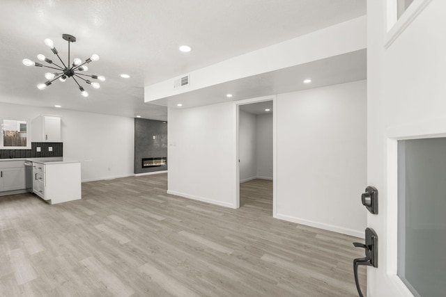 7525 Gill St NE, Albuquerque, NM 87109 - unfurnished living room with a chandelier, a fireplace, light wood-style floors, recessed lighting, and baseboards