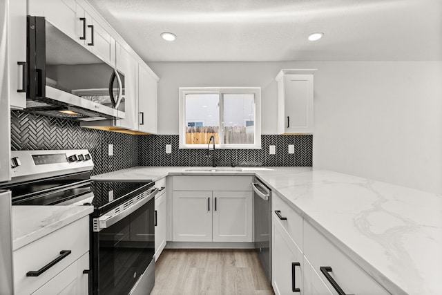 7525 Gill St NE, Albuquerque, NM 87109 - kitchen featuring appliances with stainless steel finishes, a sink, white cabinets, decorative backsplash, and recessed lighting