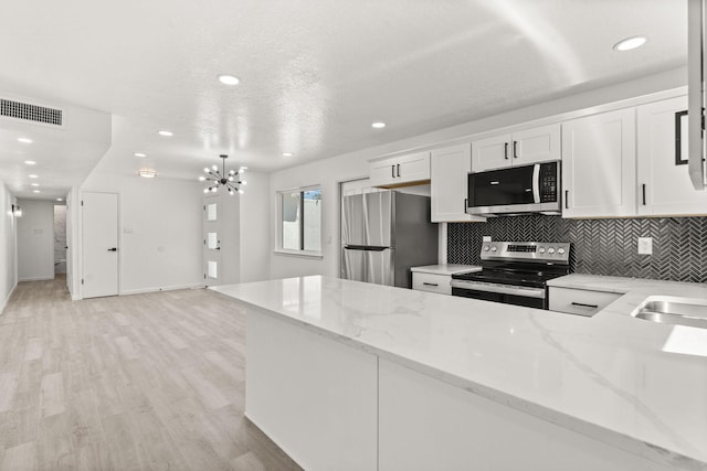 7525 Gill St NE, Albuquerque, NM 87109 - kitchen featuring stainless steel appliances, white cabinetry, light stone counters, decorative backsplash, and recessed lighting