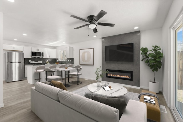 7525 Gill St NE, Albuquerque, NM 87109 - living room with baseboards, light wood finished floors, recessed lighting, ceiling fan, and a fireplace