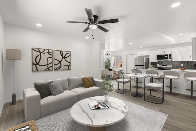 7525 Gill St NE, Albuquerque, NM 87109 - living room with recessed lighting, ceiling fan, light wood-type flooring, baseboards, and a chandelier