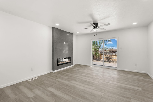 7525 Gill St NE, Albuquerque, NM 87109 - unfurnished living room with ceiling fan, recessed lighting, wood finished floors, a large fireplace, and baseboards