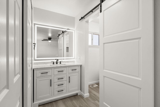 7525 Gill St NE, Albuquerque, NM 87109 - bathroom with vanity, wood finished floors, ceiling fan, and baseboards