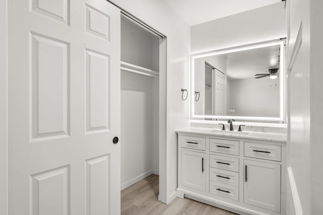 7525 Gill St NE, Albuquerque, NM 87109 - bathroom featuring vanity, wood finished floors, ceiling fan, and baseboards