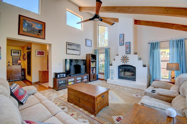 2865 Tramway Cir NE, Albuquerque, NM 87122 - living area featuring a ceiling fan, high vaulted ceiling, beam ceiling, a glass covered fireplace, and baseboards