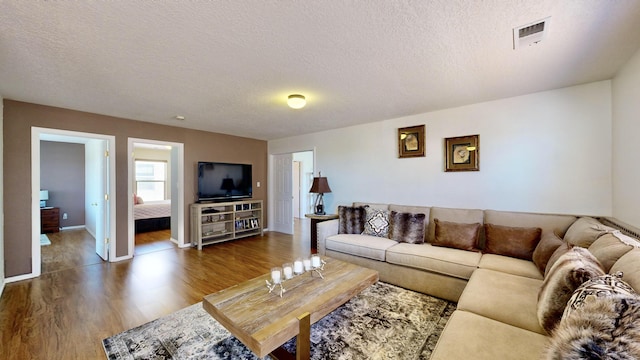 3032 Cochiti St NE, Rio Rancho, NM 87144 - living area featuring wood finished floors, a textured ceiling, and baseboards