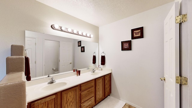 3032 Cochiti St NE, Rio Rancho, NM 87144 - bathroom with double vanity, toilet, a textured ceiling, and baseboards