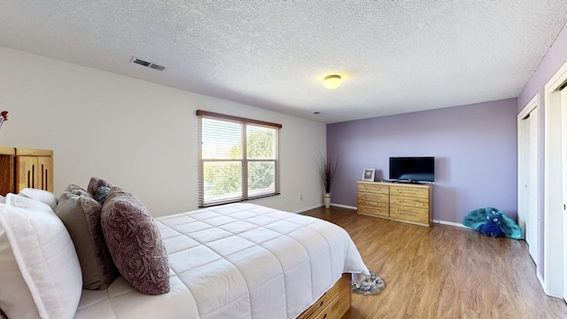 3032 Cochiti St NE, Rio Rancho, NM 87144 - bedroom featuring light wood finished floors, a textured ceiling, and baseboards