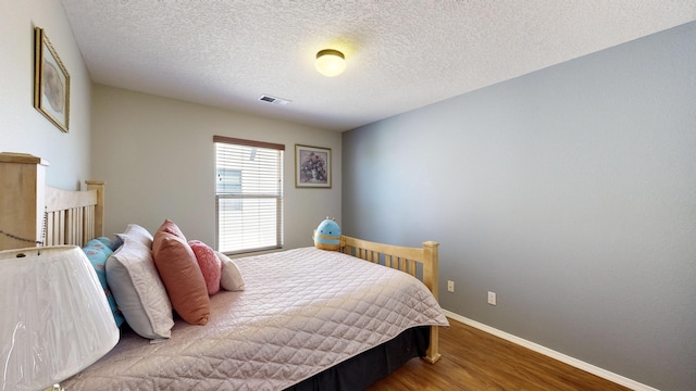 3032 Cochiti St NE, Rio Rancho, NM 87144 - bedroom with wood finished floors, baseboards, and a textured ceiling
