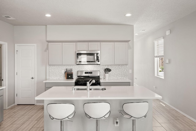 684 Turmalina Dr SE, Rio Rancho, NM 87124 - kitchen with appliances with stainless steel finishes, backsplash, light countertops, a textured ceiling, and recessed lighting