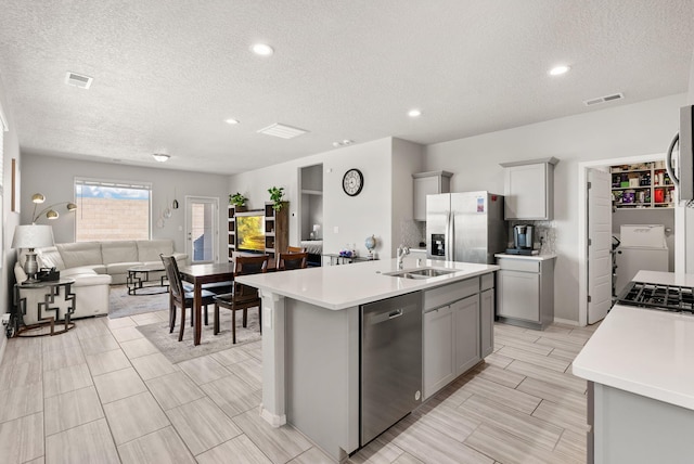 684 Turmalina Dr SE, Rio Rancho, NM 87124 - kitchen featuring appliances with stainless steel finishes, gray cabinets, a sink, open floor plan, and a textured ceiling
