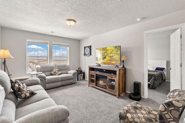 684 Turmalina Dr SE, Rio Rancho, NM 87124 - living area featuring carpet flooring, a textured ceiling, a glass covered fireplace, and baseboards