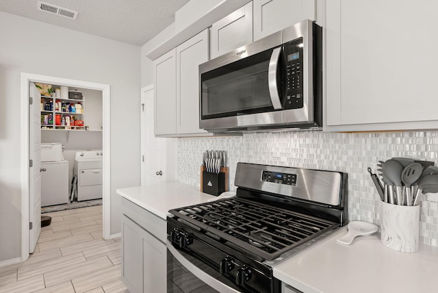 684 Turmalina Dr SE, Rio Rancho, NM 87124 - kitchen featuring stainless steel appliances, independent washer and dryer, light countertops, and tasteful backsplash