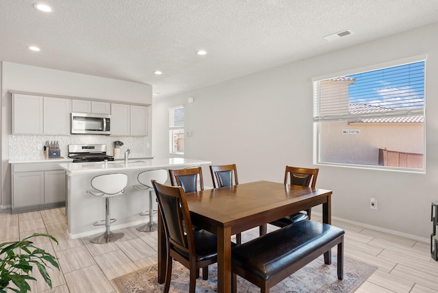 684 Turmalina Dr SE, Rio Rancho, NM 87124 - dining space featuring plenty of natural light, recessed lighting, a textured ceiling, and baseboards