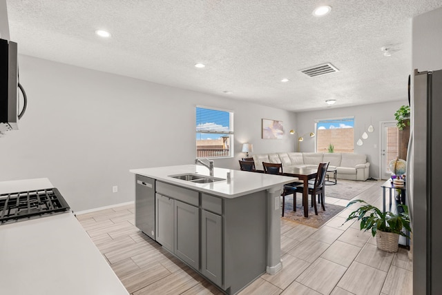 684 Turmalina Dr SE, Rio Rancho, NM 87124 - kitchen with stainless steel appliances, a sink, gray cabinetry, wood finish floors, and open floor plan