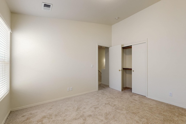 6501 San Antonio Dr NE Unit 2702, Albuquerque, NM 87109 - unfurnished bedroom featuring light colored carpet, multiple windows, and baseboards