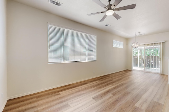 6501 San Antonio Dr NE Unit 2702, Albuquerque, NM 87109 - unfurnished room with a chandelier, light wood-type flooring, baseboards, and a ceiling fan